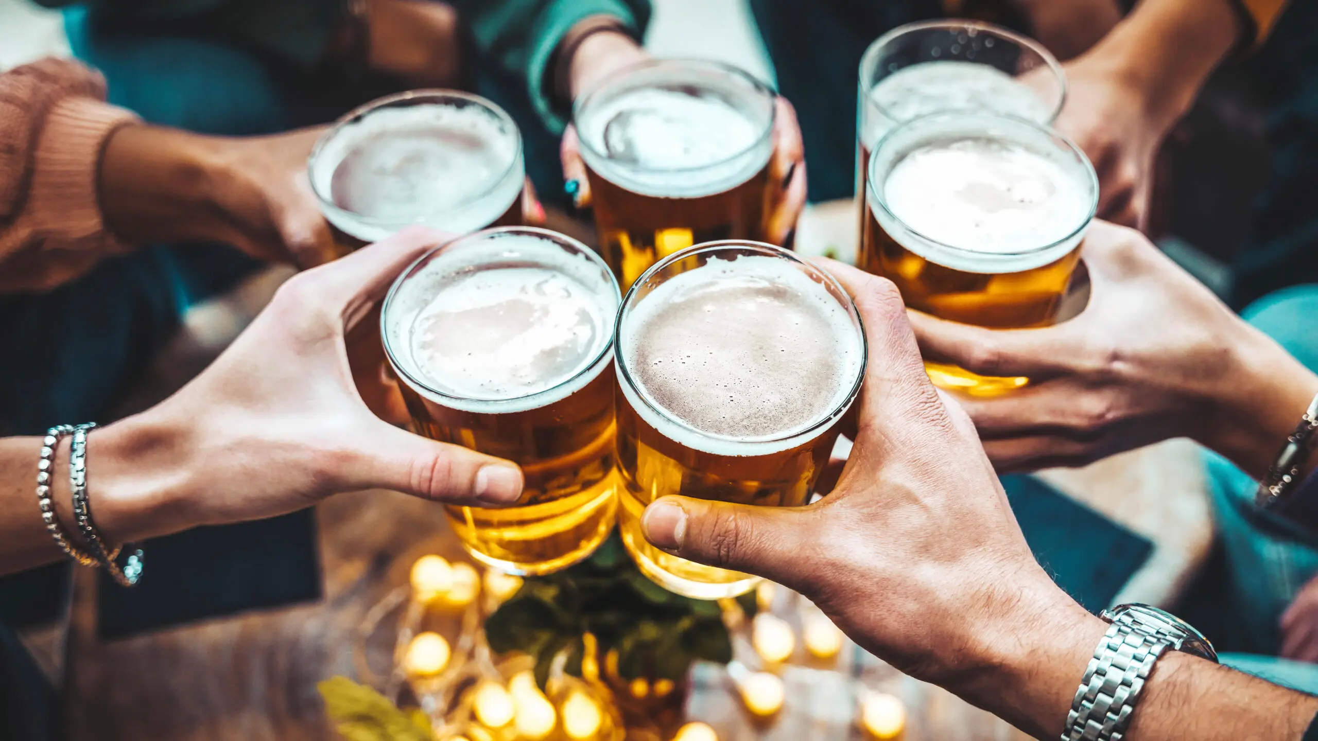 Group of people cheering their beers together